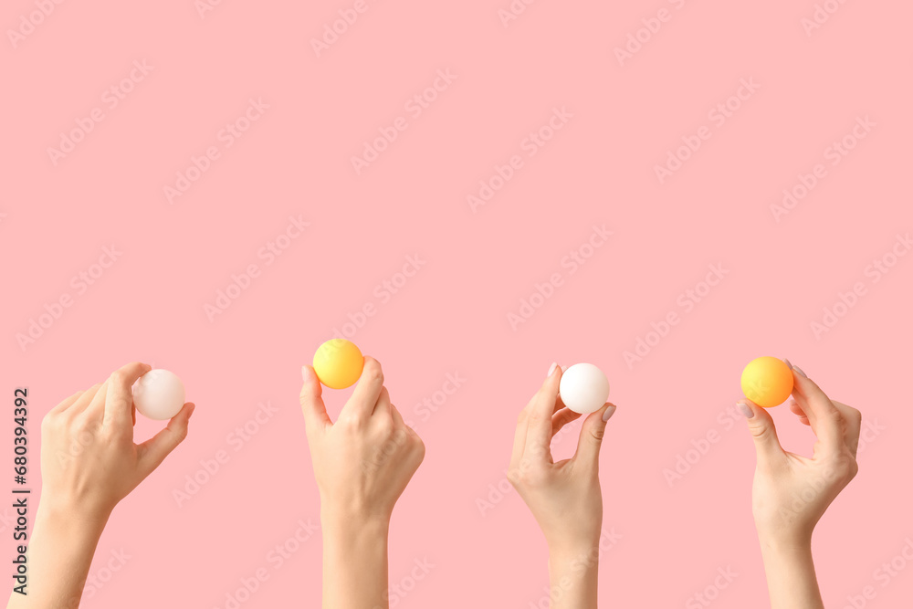 Female hands with tennis balls on pink background