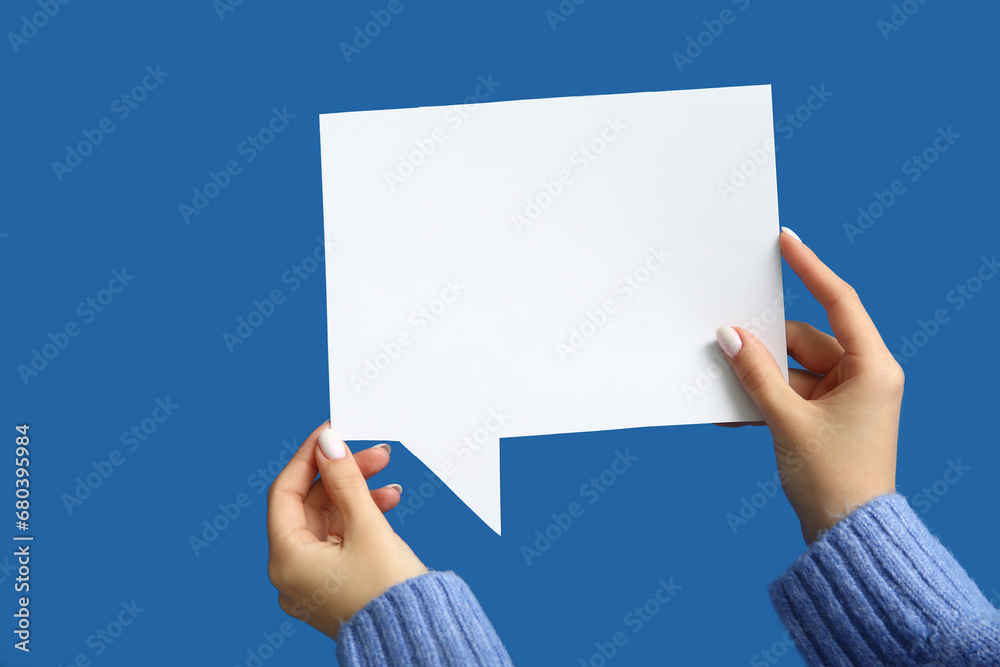 Female hands with blank speech bubble on blue background