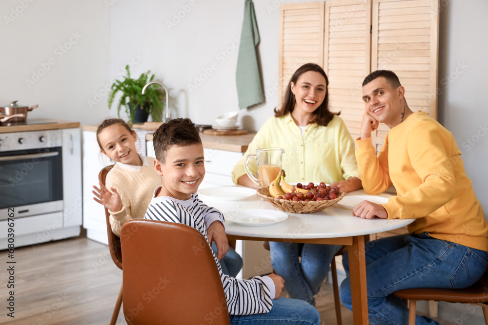 Happy family sitting at dining table in kitchen