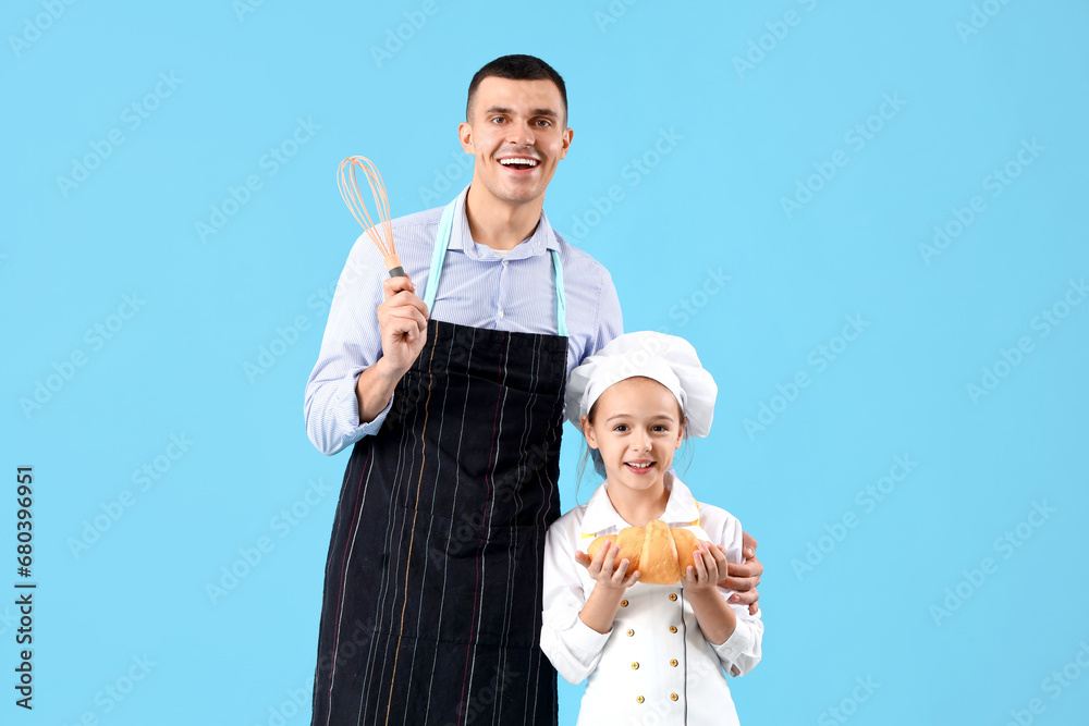 Little chef with croissant and her father on blue background