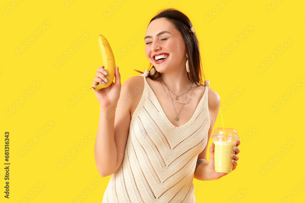 Young woman with glass of smoothie and banana on yellow background