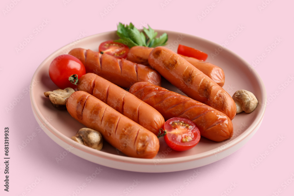 Plate with tasty grilled sausages on pink background