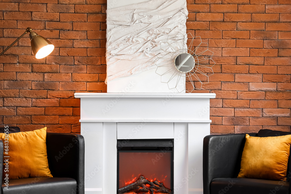 Stylish fireplace and armchairs near brick wall