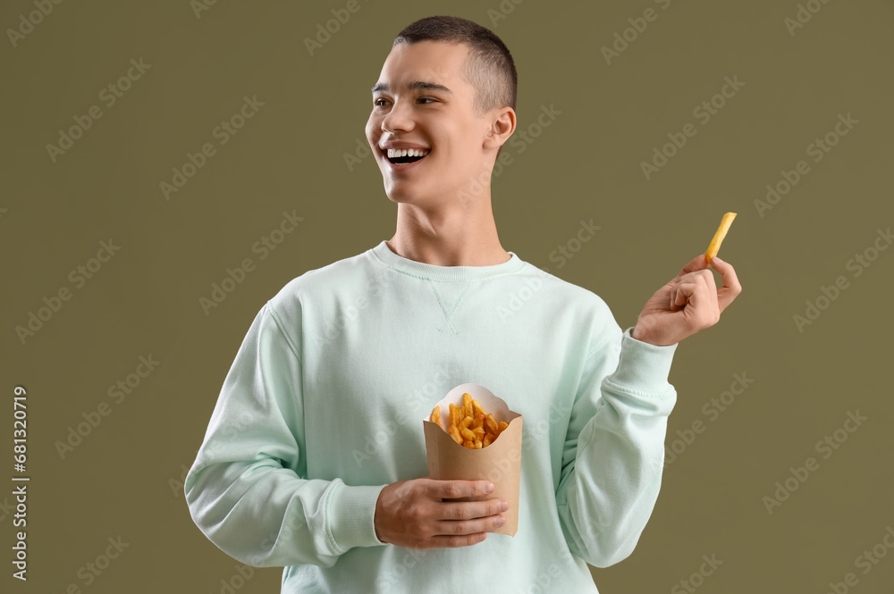 Young man with french fries on color background