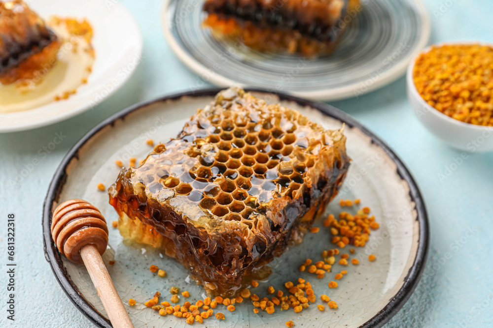 Plate with sweet honeycomb on blue background