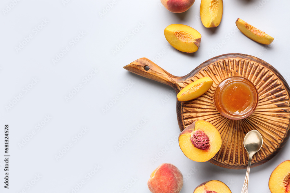 Wooden board with jar of tasty peach jam and fresh fruits on light background