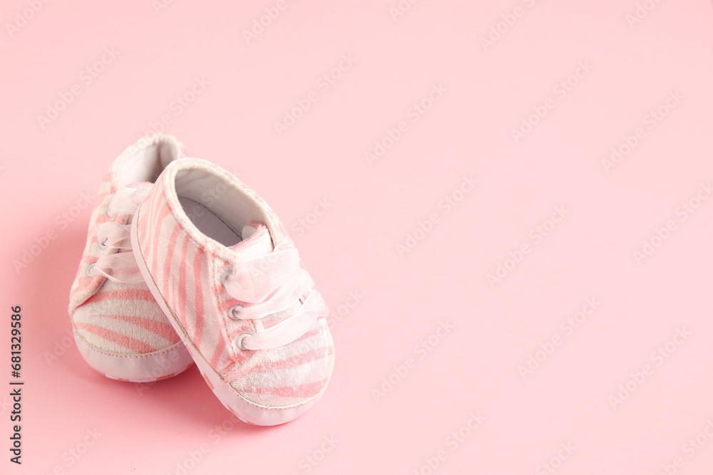 Stylish baby shoes on pink background