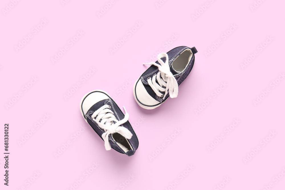 Stylish baby shoes on purple background