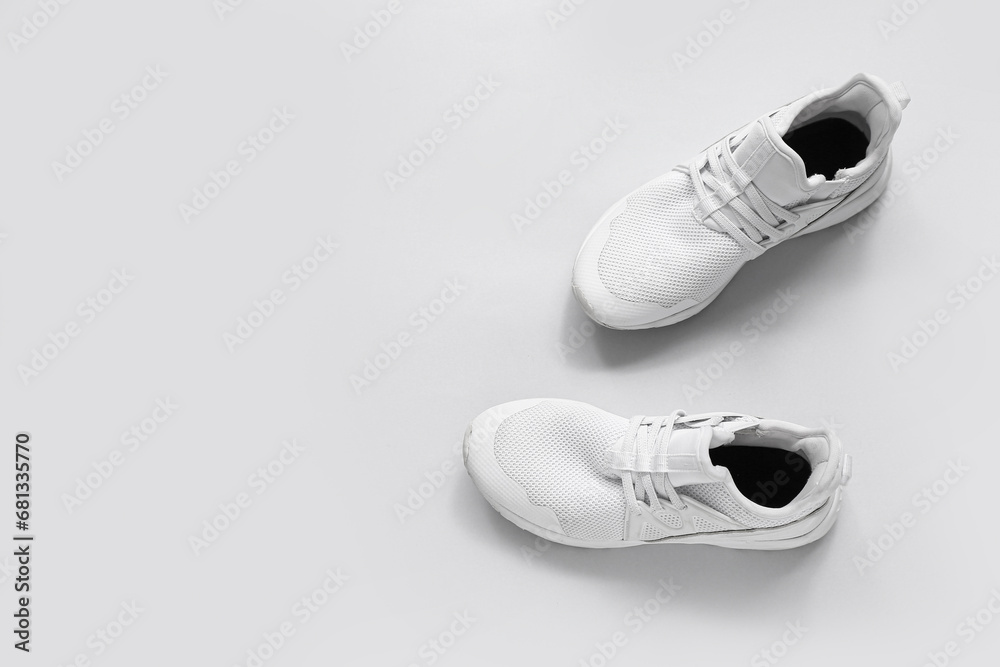 Stylish white sneakers on grey background