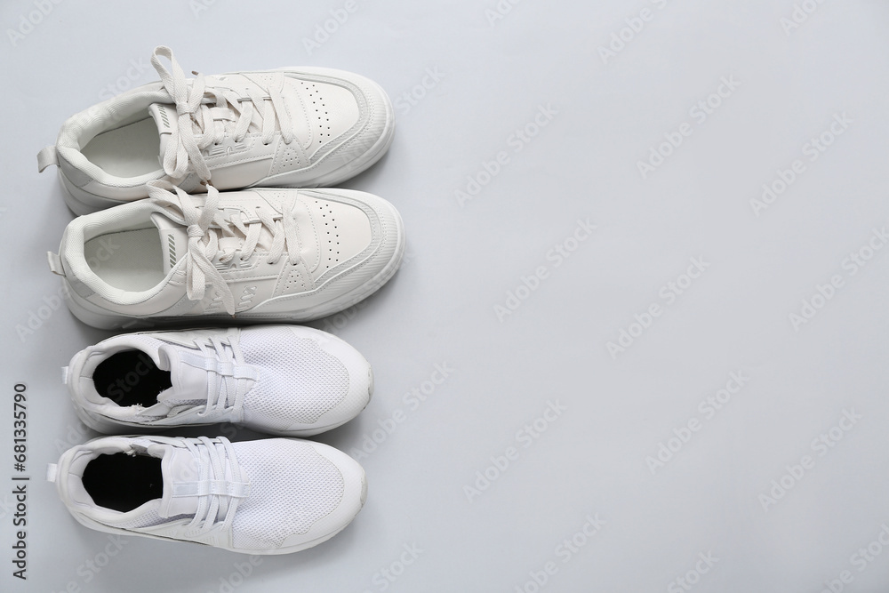 Stylish white sneakers on grey background