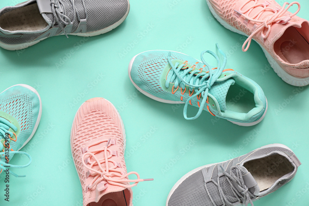 Different stylish sneakers on turquoise background