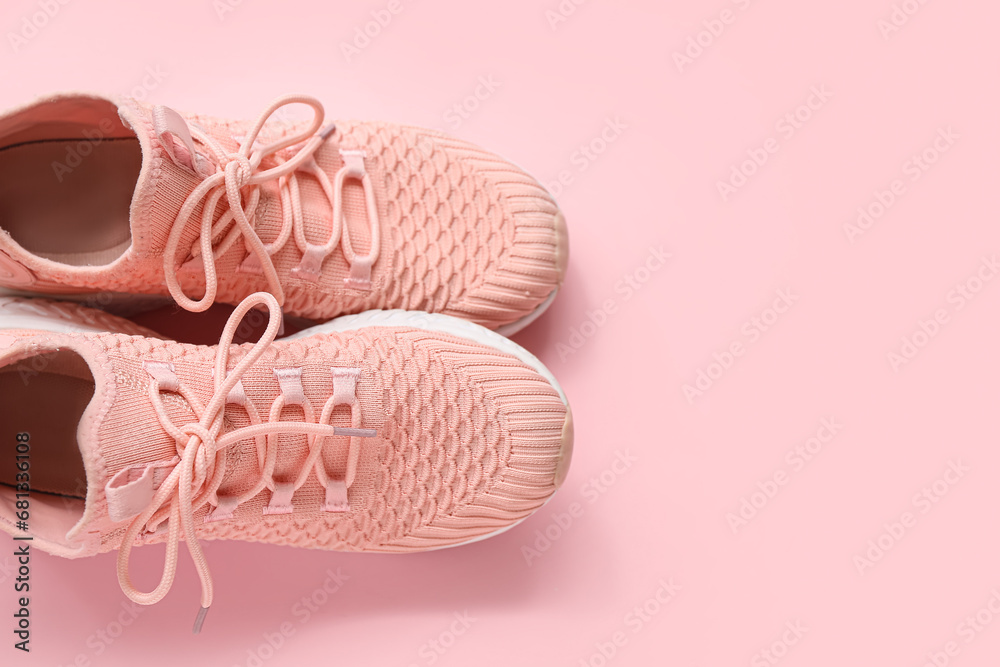 Stylish pink sneakers on color background