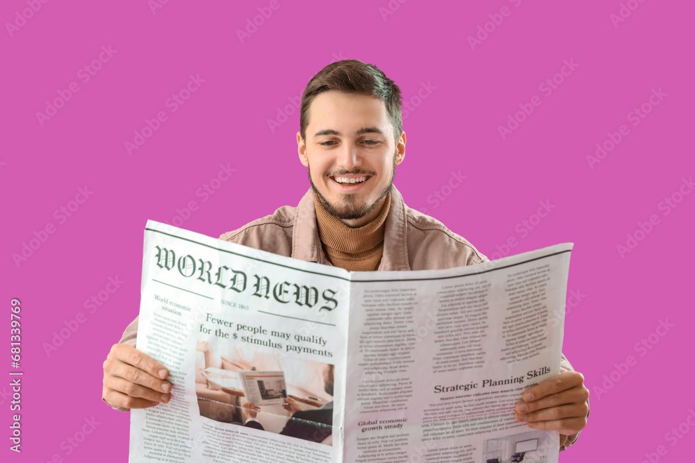 Young man reading newspaper on purple background