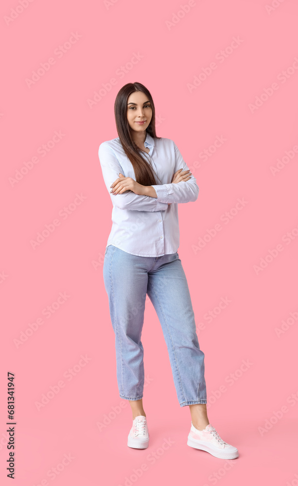 Beautiful young woman in stylish white sneakers on pink background