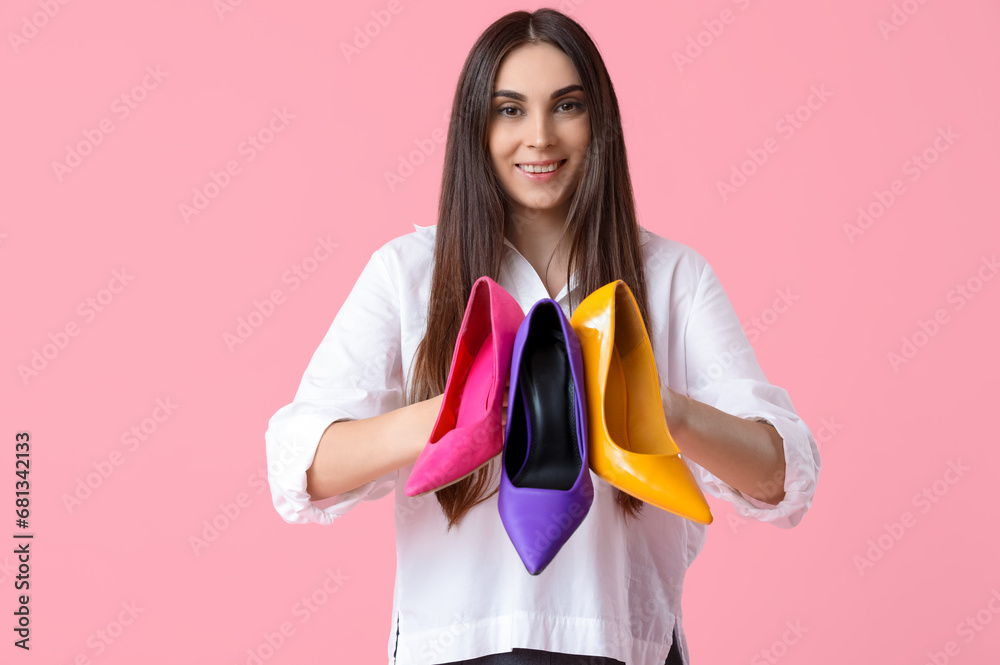 Beautiful young woman with different stylish high heels on pink background