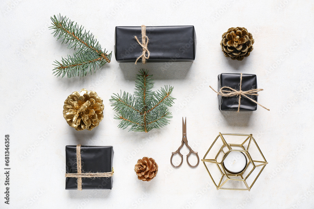 Painted golden pine cones with Christmas gift boxes, fir branches and candle on white background