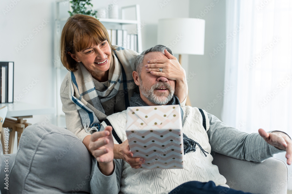 Caucasian senior elderly woman surprise her husband with birthday gift. 