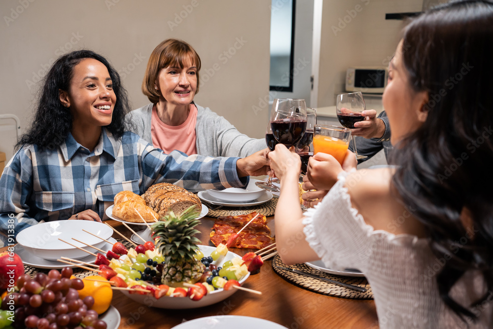 Multi-ethnic big family having dinner, enjoy evening party in house. 