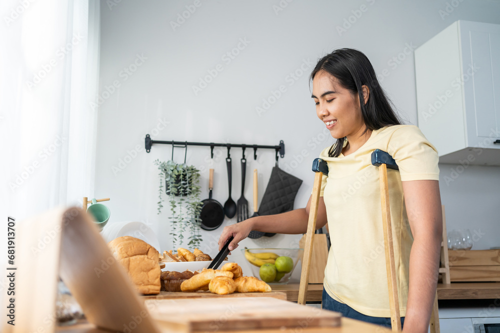 Asian female amputee baking bakery for selling in kitchen at home. 