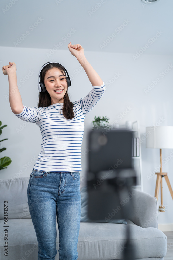 Asian attractive woman enjoy dance with music in living room at home.