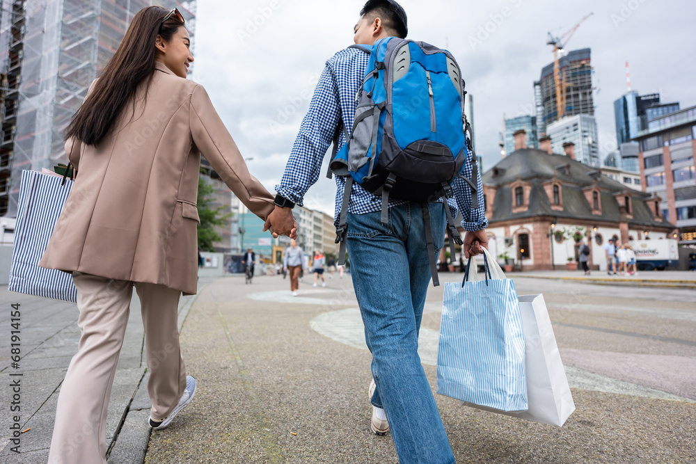 Asian young man and woman shopping goods outdoors in department store.