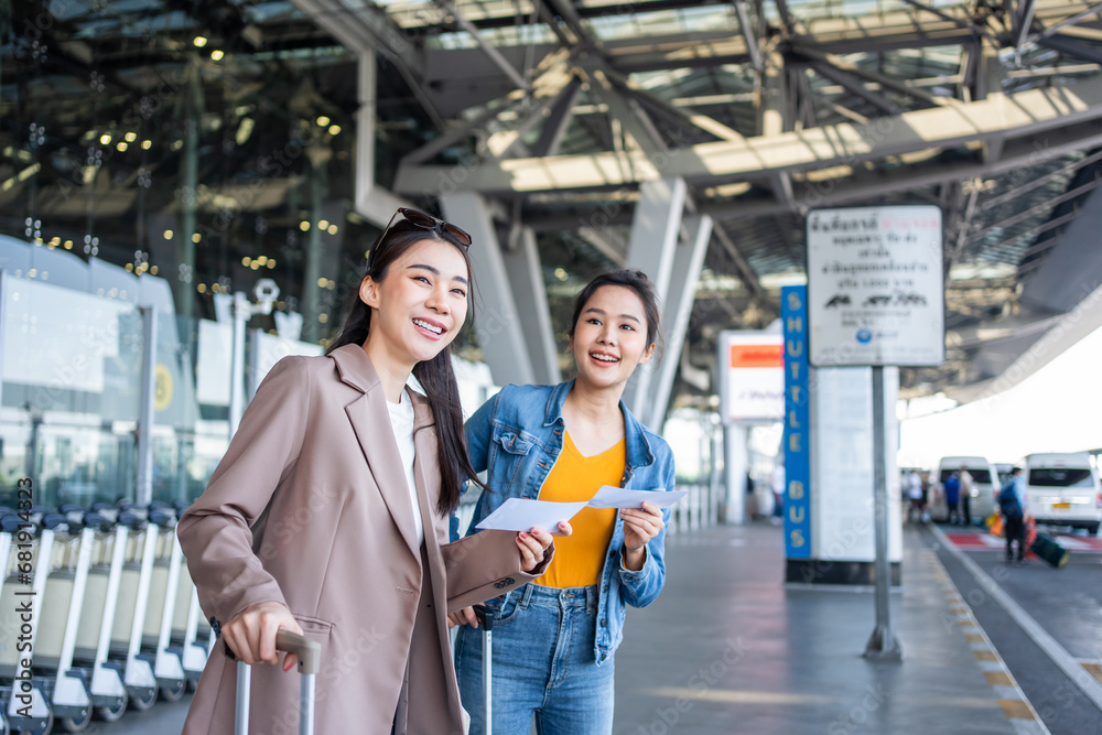 Asian two women passenger waiting a bus after leaving from the airport. 