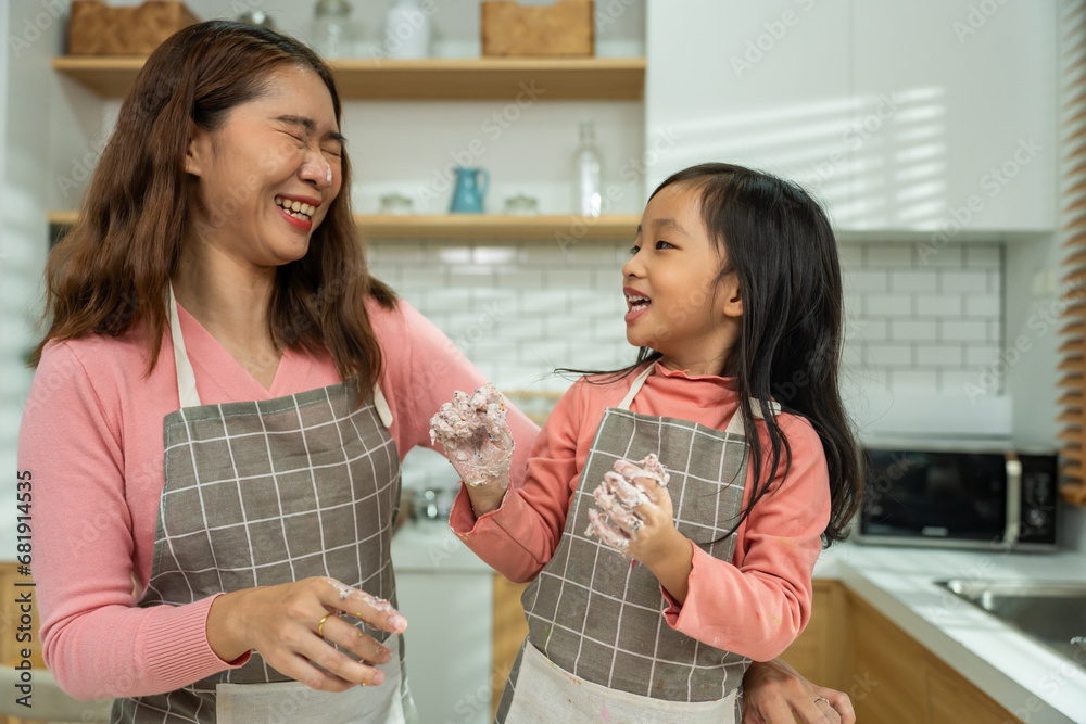 Asian attractive mother making cake with daughter in kitchen at house. 