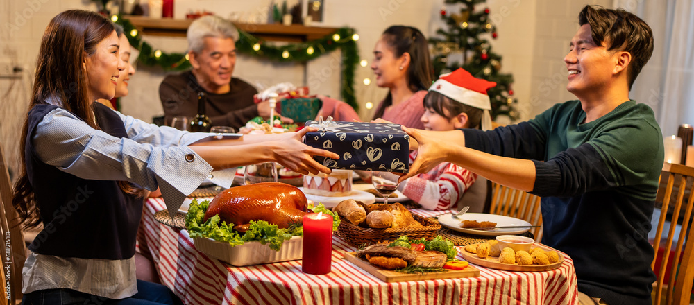 Asian lovely family exchanging presents during Christmas party at home. 