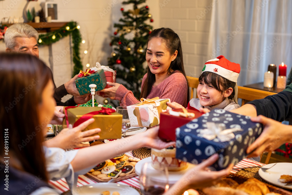 Asian lovely family exchanging presents during Christmas party at home. 