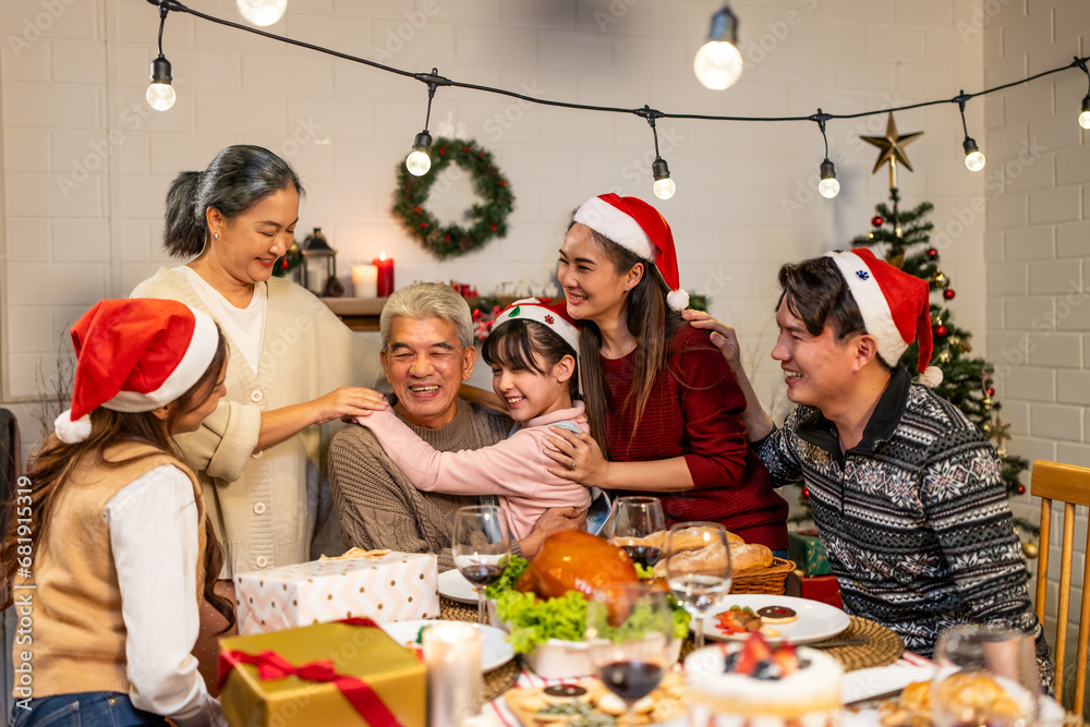 Asian kid hugging grandparent while celebrate Christmas party in house. 