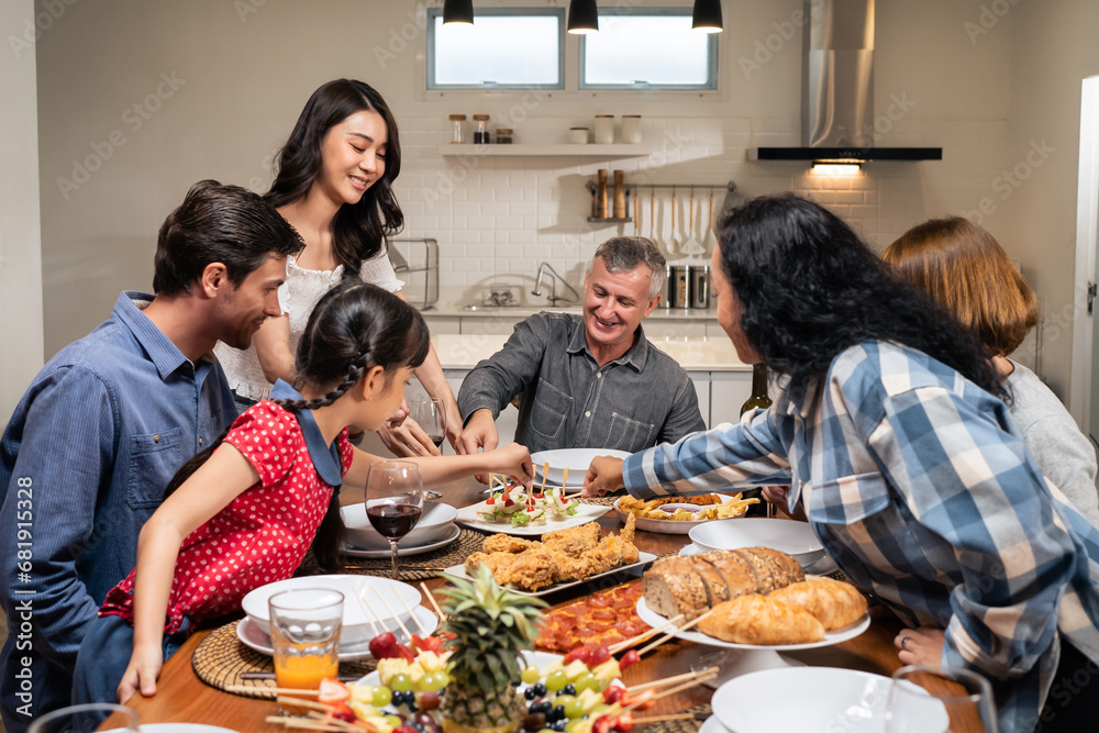 Multi-ethnic big family having dinner, enjoy evening party in house. 