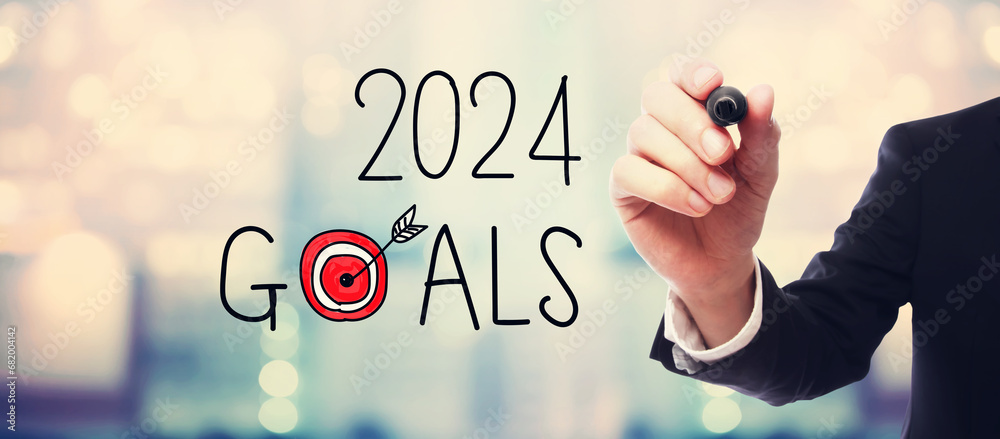 2024 Goals with businessman on blurred abstract background