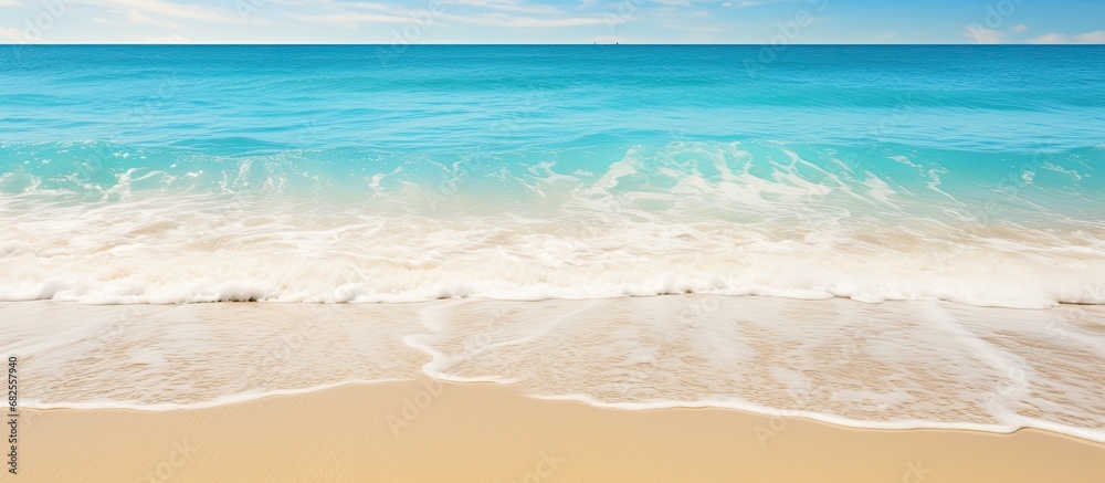 On a beautiful beach in the midst of summer, an abstract texture of water gently caresses the soft sand, as travelers revel in the concept of tranquility and relaxation, indulging in a refreshing hand